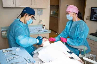 Dr. Kang and his assistant providing dental care for a patient